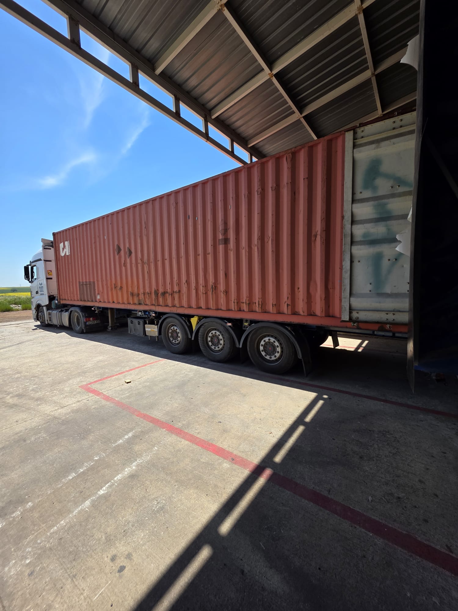 Container truck positioned for loading